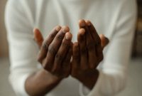 Foto: Ilustrasi berdoa dengan khusyuk di sekitar pusara, menciptakan suasana yang syahdu. Lalu, benarkah wanita dilarang ziarah kubur? Begini penjelasan Gus Baha. (Freepik)