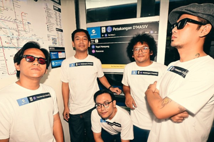 Foto memperlihatkan kelima personil D'Masiv berdiri di depan plakat nama halte TransJakarta yang baru, 