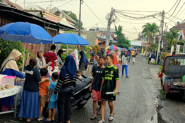 Anggota Karang Taruna Unit 016 Kelurahan Uwung Jaya membagikan takjil kepada pengguna jalan di wilayah Kelurahan Uwung Jaya pada bulan Ramadan.