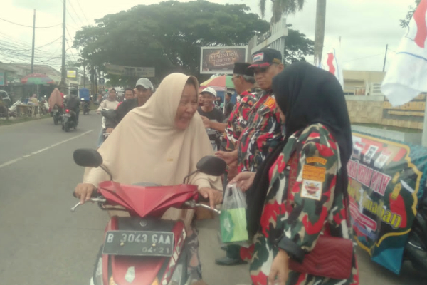 Seorang warga menerima takjil dari Laskar Merah Putih Rajeg Tangerang Banten