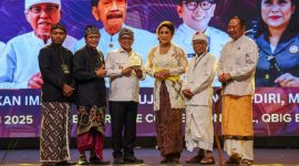 Gubernur Banten Andra Soni (tengah, berbaju putih) menerima cendera mata dari panitia pelaksana saat menghadiri acara Dharma Santi Banten 2025. (Dok. Biro Adminpro Banten). 