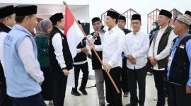 Wakil Gubernur Banten, A Dimyati Natakusumah, secara simbolis menyerahkan bendera Merah Putih kepada perwakilan jemaah haji Kloter 57-JKG. (Dok. Biro Adpimpro Banten). 