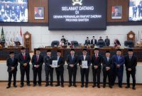 Gubernur Banten Andra Soni (tengah, mengenakan setelan abu-abu tua dan peci hitam) bersama Wakil Gubernur A. Dimyati Natakusumah dan jajaran pimpinan serta anggota Dewan Perwakilan Rakyat Daerah (DPRD) Provinsi Banten dalam rangkaian rapat paripurna DPRD Provinsi Banten. (Dok. Biro Adpimpro Banten). 