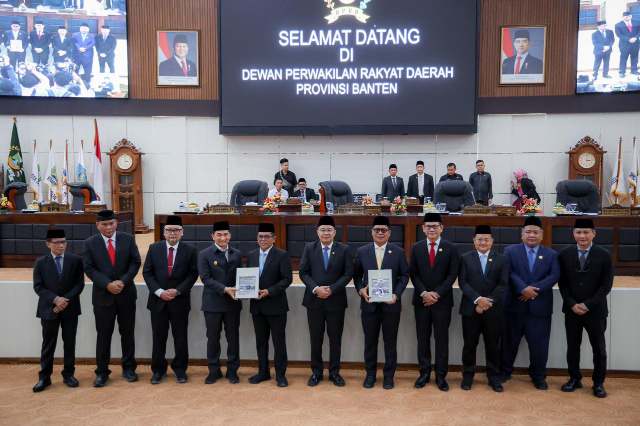 Gubernur Banten Andra Soni (tengah, mengenakan setelan abu-abu tua dan peci hitam) bersama Wakil Gubernur A. Dimyati Natakusumah dan jajaran pimpinan serta anggota Dewan Perwakilan Rakyat Daerah (DPRD) Provinsi Banten dalam rangkaian rapat paripurna DPRD Provinsi Banten. (Dok. Biro Adpimpro Banten). 