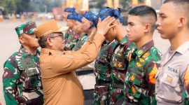 Gubernur Banten Andra Soni mengenakan ikat kepala khas Banten kepada salah satu peserta taruna dalam upacara penyambutan Latsitarda Nusantara ke-45 di Dermaga Pelabuhan Indah Kiat, Kota Cilegon. (Dok. Biro Adpimpro Banten). 