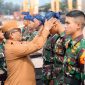 Gubernur Banten Andra Soni mengenakan ikat kepala khas Banten kepada salah satu peserta taruna dalam upacara penyambutan Latsitarda Nusantara ke-45 di Dermaga Pelabuhan Indah Kiat, Kota Cilegon. (Dok. Biro Adpimpro Banten). 
