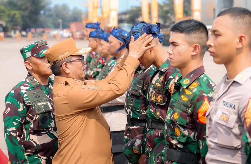 Gubernur Banten Andra Soni mengenakan ikat kepala khas Banten kepada salah satu peserta taruna dalam upacara penyambutan Latsitarda Nusantara ke-45 di Dermaga Pelabuhan Indah Kiat, Kota Cilegon. (Dok. Biro Adpimpro Banten). 