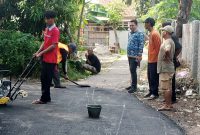 Foto: Kepala Desa Karang Anyar, Suhendri (berbaju batik biru), meninjau langsung proses pengerjaan jalan hotmix yang bersumber dari Dana Desa. (Dok. Ahmad/Metrosiar). 