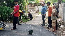 Foto: Kepala Desa Karang Anyar, Suhendri (berbaju batik biru), meninjau langsung proses pengerjaan jalan hotmix yang bersumber dari Dana Desa. (Dok. Ahmad/Metrosiar). 
