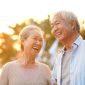 senior asian couple enjoying good time outdoors in park at dusk, happy and smiling
