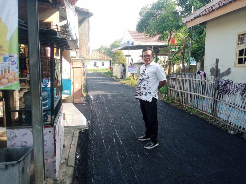 Foto: Kepala Desa Patra Manggala, Jayadi, saat meninjau langsung proses pengerjaan jalan hotmix swakelola desa di wilayahnya. (Dok. Ahmad/Metrosiar) 