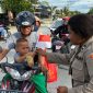 Polwan Polres Keerom membagikan 300 Bendera Merah Putih dan 200 stiker kepada pengendara di Jalan Bhayangkara, Keerom, dalam rangka menyambut HUT RI ke-80 dan menumbuhkan semangat nasionalisme masyarakat. (Foto: DOK. Tribratanews)