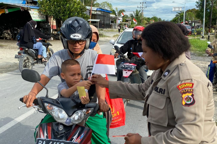 Polwan Polres Keerom membagikan 300 Bendera Merah Putih dan 200 stiker kepada pengendara di Jalan Bhayangkara, Keerom, dalam rangka menyambut HUT RI ke-80 dan menumbuhkan semangat nasionalisme masyarakat. (Foto: DOK. Tribratanews)