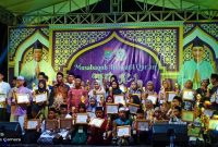 Para pemenang MTQ Ke-1 Desa Kemiri berfoto bersama panitia, tokoh masyarakat, dan unsur Forkopimcam setelah prosesi penyerahan piala dan piagam penghargaan di panggung utama