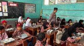 Siswa menikmati makanan bergizi dalam program SPPG, dengan pendampingan petugas untuk memastikan distribusi berjalan aman dan tertib.