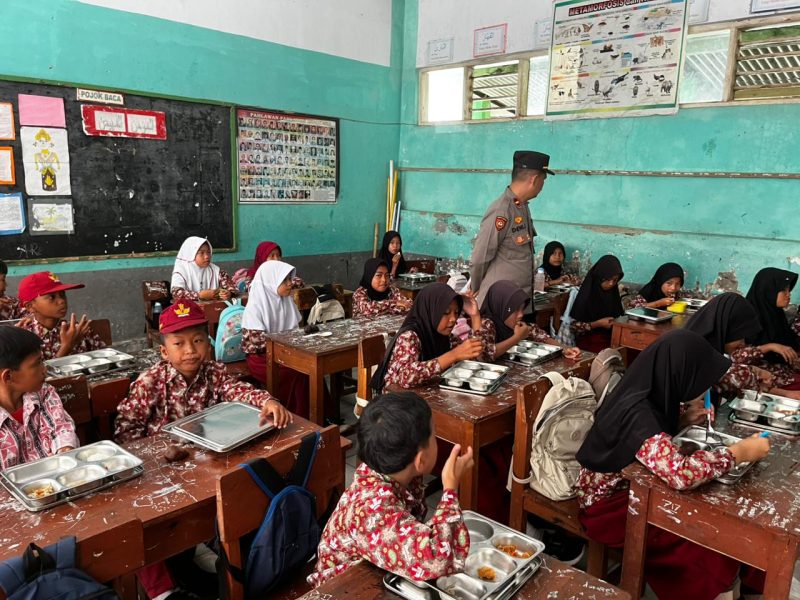 Siswa menikmati makanan bergizi dalam program SPPG, dengan pendampingan petugas untuk memastikan distribusi berjalan aman dan tertib.
