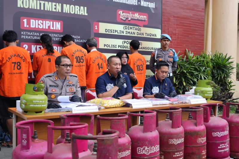 Polda Banten memaparkan kronologi dan modus penyalahgunaan LPG subsidi dalam konferensi pers, sementara para tersangka diperlihatkan di belakang meja barang bukti.