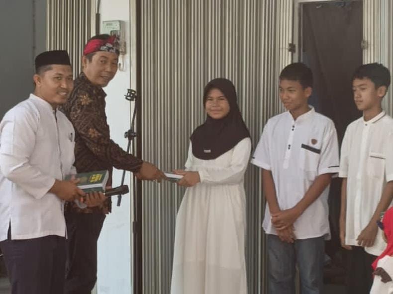 Penyerahan wakaf buku Juzz 30 Ummi secara simbolis oleh Wakil Ketua DPD Partai Gelora, Supriyatna, S.E., kepada para santri, didampingi Pimpinan Madrasah Quraniyyah, Ustaz Hamdan Matondang, S.Pd.I. (Foto: Metrosiar)