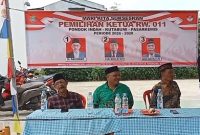 Panitia dan perwakilan tokoh masyarakat duduk di meja utama dengan latar spanduk pemilihan Ketua RW 011 Kutabumi periode 2025–2028, menandai jalannya proses demokrasi secara terbuka dan transparan.