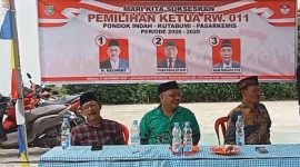 Panitia dan perwakilan tokoh masyarakat duduk di meja utama dengan latar spanduk pemilihan Ketua RW 011 Kutabumi periode 2025–2028, menandai jalannya proses demokrasi secara terbuka dan transparan.