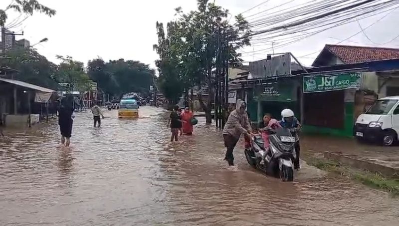 Banjir merendam Jalan Raya Serang–Pandeglang di KM 12 Baros, menyebabkan aktivitas warga dan arus lalu lintas terganggu akibat luapan Sungai Cipareang.