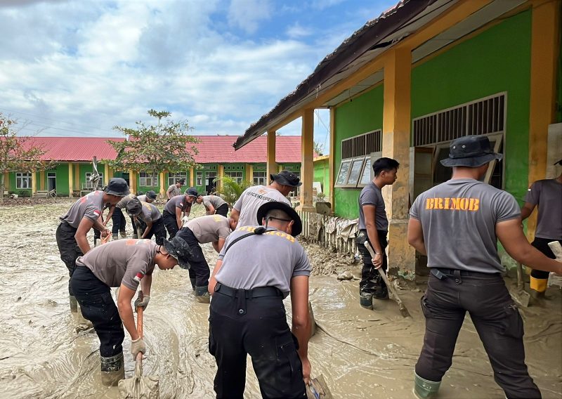 Personel Brimob Polda Banten bersama tim gabungan berjibaku membersihkan lumpur di lingkungan Dayah Babussalam Baktiya, Aceh Utara, pascabencana.