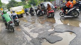 Jalan Raya Pasar Kemis rusak parah dan dipenuhi lubang besar yang tergenang air. Pengendara motor harus ekstra hati-hati saat melintas karena licin dan rawan kecelakaan.