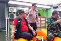 Petugas gabungan TNI-Polri dan pemerintah kecamatan menggunakan perahu karet untuk menjangkau permukiman warga yang terendam banjir di Desa Gelam Jaya, Pasar Kemis, guna memastikan keselamatan serta distribusi bantuan berjalan lancar.
