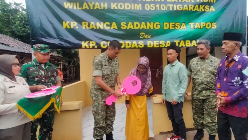 Dandim 0510/Tigaraksa, Letkol Inf Yudho Setyono, S.H., menyerahkan kunci rumah secara simbolis kepada warga penerima manfaat program rehabilitasi rumah tidak layak huni di Kampung Ranca Sadang, Desa Tapos, Jumat (23/01), dalam rangka HUT Korem 052/Wijayakrama ke-27.