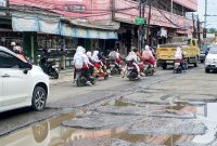 Sejumlah pelajar melintasi jalan rusak di kawasan Pasar Kemis, Kabupaten Tangerang, yang menjadi akses utama menuju sekolah setiap hari.