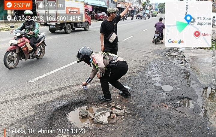 Personel Unit Kamsel Satlantas Polresta Tangerang melakukan penandaan titik jalan berlubang di jalur utama Kabupaten Tangerang sebagai bagian dari persiapan pengamanan mudik Lebaran 2026.
