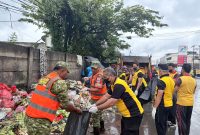 Personel Koramil 02/Curug bersama jajaran Polsek Curug dan warga bergotong royong mengangkut tumpukan sampah di Jalan Raya STPI Curug.
