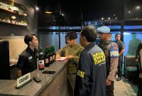 Petugas Ditreskrimum dan Sabhara Polda Banten melakukan pemeriksaan di salah satu tempat usaha saat Operasi Pekat Maung 2026, dengan mengamankan sejumlah minuman keras dari lokasi.