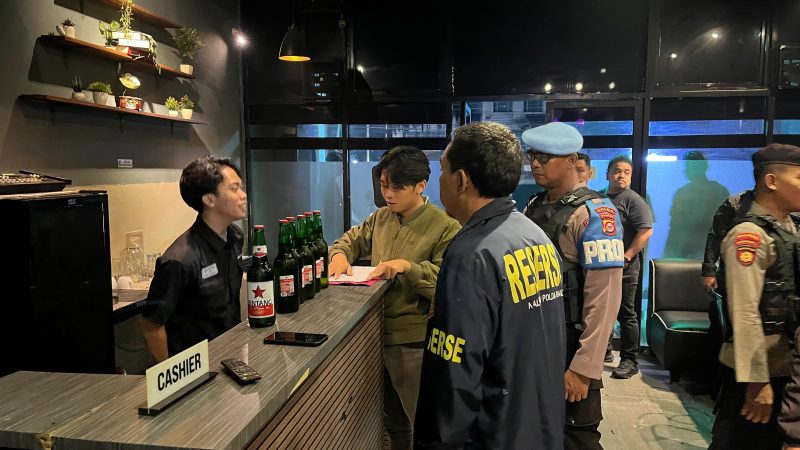 Petugas Ditreskrimum dan Sabhara Polda Banten melakukan pemeriksaan di salah satu tempat usaha saat Operasi Pekat Maung 2026, dengan mengamankan sejumlah minuman keras dari lokasi.