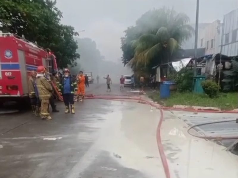Petugas pemadam kebakaran berjaga di lokasi pabrik bahan kimia yang terbakar, diduga menjadi sumber pencemaran air baku.