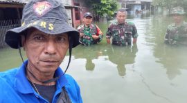Jurnalis Metrosiar Alex Salembun (kaos biru) bersama Danramil Pasar Kemis Mayor Arm Sidik Abriyanto dan anggota TNI saat meninjau banjir yang merendam permukiman warga di RW 17 Vila Tomang Baru, Desa Gelam Jaya, Kecamatan Pasar Kemis, Kabupaten Tangerang, Minggu (08/03/2026).