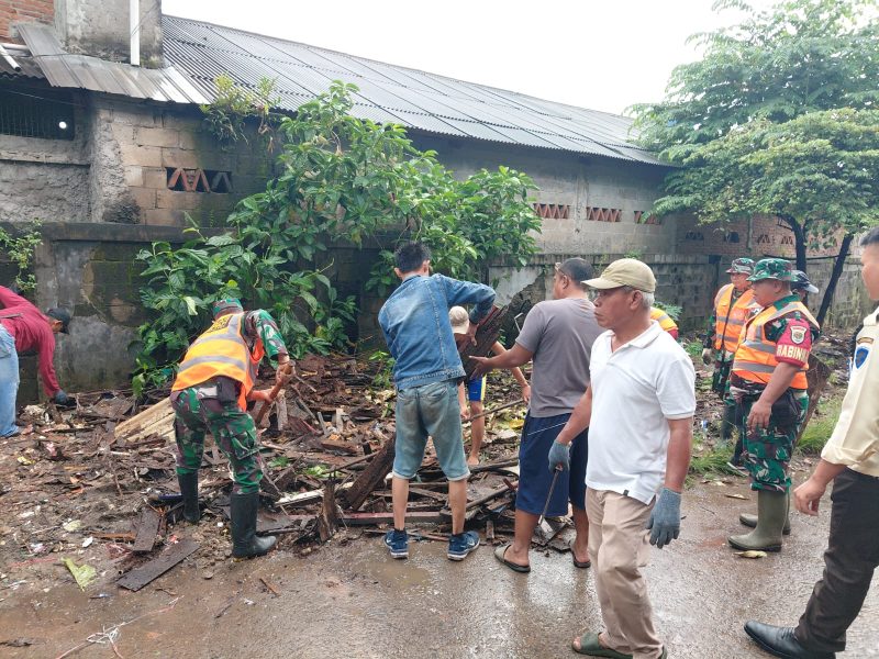 Personel Satgas Sampah Koramil 02/Curug bersama warga membersihkan tumpukan sampah di Jalan Raya STPI Curug, Desa Kadu Jaya, Kabupaten Tangerang.