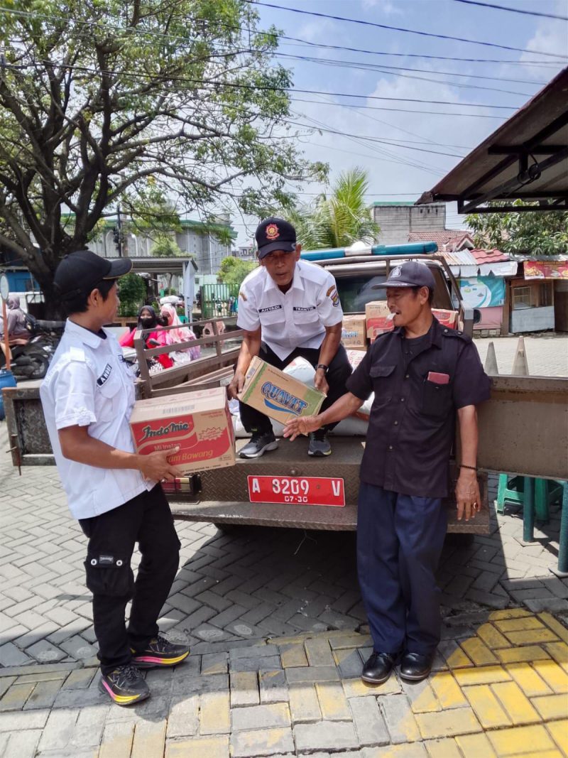 Petugas Kecamatan Pasar Kemis menurunkan bantuan sembako dari kendaraan operasional untuk didistribusikan kepada warga terdampak banjir di Kelurahan Gelam Jaya, Kabupaten Tangerang.