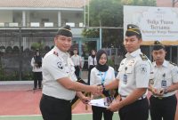 Kepala Lapas Kelas IIA Serang, Riko Stiven, menyerahkan surat keputusan kenaikan pangkat kepada salah satu pegawai dalam upacara penyematan kenaikan pangkat yang digelar di lapangan apel Lapas IIA Serang, Kamis (12/3/2026).