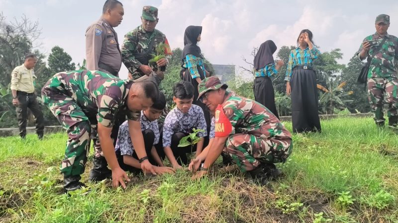 Anggota Koramil 11/Pasar Kemis bersama siswa SMPN 3 Pasar Kemis dan aparat terkait menanam bibit pohon secara gotong royong.