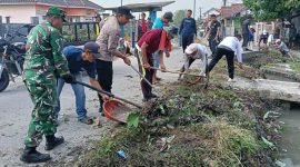 Personel TNI bersama aparat dan warga bergotong royong membersihkan tumpukan sampah dan rumput liar di saluran air kawasan Kampung Buaran Mangga, Kecamatan Pakuhaji.