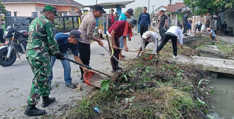 Personel TNI bersama aparat dan warga bergotong royong membersihkan tumpukan sampah dan rumput liar di saluran air kawasan Kampung Buaran Mangga, Kecamatan Pakuhaji.
