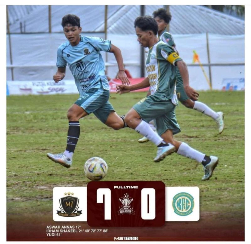 Pemain Makmur Jaya FC (jersey biru muda) berusaha melewati hadangan pemain Kodingeh FC dalam laga Turnamen Belajen Cup 1. Makmur Jaya tampil dominan dan menutup pertandingan dengan kemenangan telak 7-0.