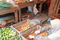 Pedagang menunjukkan tomat yang mengalami kenaikan harga hingga tembus Rp900 ribu per peti.