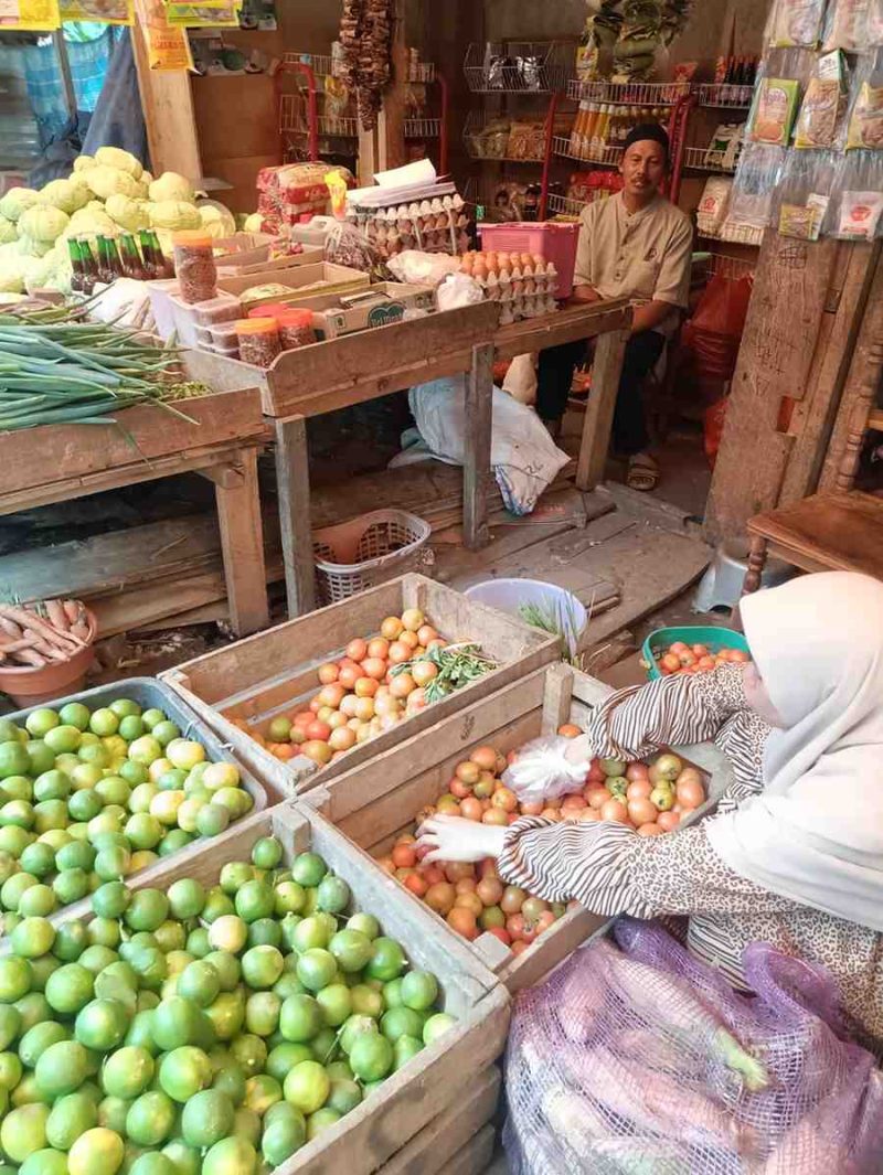 Pedagang menunjukkan tomat yang mengalami kenaikan harga hingga tembus Rp900 ribu per peti.