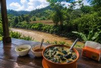 Semangkuk kapurung khas Sulawesi disajikan hangat di Warung Mbak Rezki, Sangeran, Kecamatan Anggeraja, dengan latar pemandangan sungai dan perbukitan hijau yang memanjakan mata.