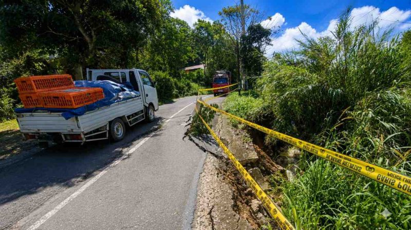 Kondisi jalan di Bubun Bia, Kecamatan Baroko, yang tergerus air akibat hujan deras selama dua hari terakhir. Pengendara terpaksa melintas bergantian karena sebagian badan jalan mengalami kerusakan dan telah dipasangi tanda peringatan.