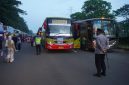 Petugas kepolisian melakukan pengamanan dan pengawasan pemberangkatan massa buruh menggunakan bus menuju Jakarta dalam rangka peringatan May Day.