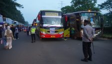 Petugas kepolisian melakukan pengamanan dan pengawasan pemberangkatan massa buruh menggunakan bus menuju Jakarta dalam rangka peringatan May Day.