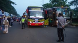 Petugas kepolisian melakukan pengamanan dan pengawasan pemberangkatan massa buruh menggunakan bus menuju Jakarta dalam rangka peringatan May Day.